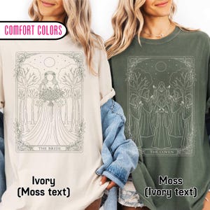 May include: Ivory and moss green Comfort Colors t-shirts. The ivory shirt features a bride illustration with the text "THE BRIDE". The moss green shirt displays a coven illustration with the text "THE COVEN".