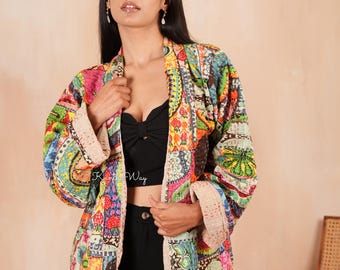 Può includere: Giacca patchwork colorata con una varietà di motivi e colori, tra cui rosa, verde, blu e giallo. La giacca ha una fodera color crema e viene indossata aperta. Parte di una collezione di abbigliamento.