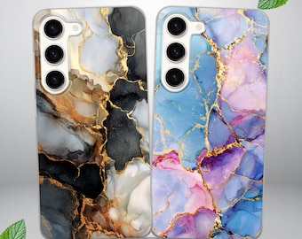 Può includere: Due custodie per telefono con design astratti. Una custodia presenta un mix di motivi marmorizzati neri, oro e bianchi. L'altra custodia mostra un design marmorizzato blu, viola e rosa con accenti dorati. Entrambe le custodie hanno un ritaglio per la fotocamera.
