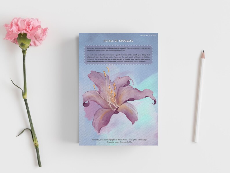 Op de afbeelding: Een rechthoekige kaart getiteld Petals of Goodness met een paarse lelie-illustratie, tekst, een roze anjer en een wit potlood. De kaart bevat gedrukte tekst over kleine goede dingen en licht tijdens uitdagende tijden.