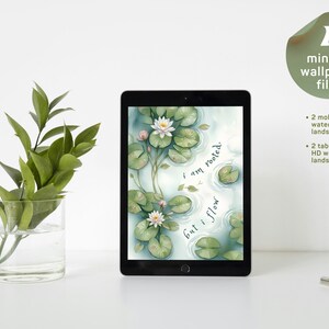 Op de afbeelding: Een zwarte tablet met een digitale aquarelillustratie van witte waterlelies en groene leliebladeren op een vijver, met de tekst "i am rooted. but i flow.". Een doorzichtige glazen vaas met groene bladeren staat links, een metalen clip rechts.