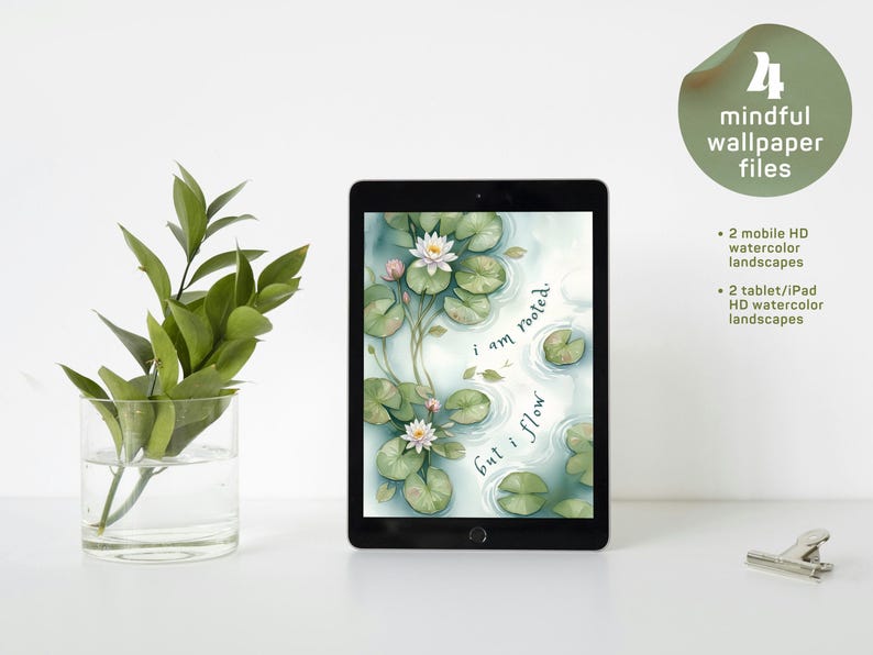 Op de afbeelding: Een zwarte tablet met een digitale aquarelillustratie van witte waterlelies en groene leliebladeren op een vijver, met de tekst "i am rooted. but i flow.". Een doorzichtige glazen vaas met groene bladeren staat links, een metalen clip rechts.