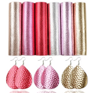 Puede incluir: Seis hojas de piel sint&eacute;tica en colores dorado, rosa y rojo. La piel tiene un aspecto texturizado y en relieve. Tres pares de pendientes en forma de l&aacute;grima hechos de piel sint&eacute;tica se muestran debajo de las hojas.