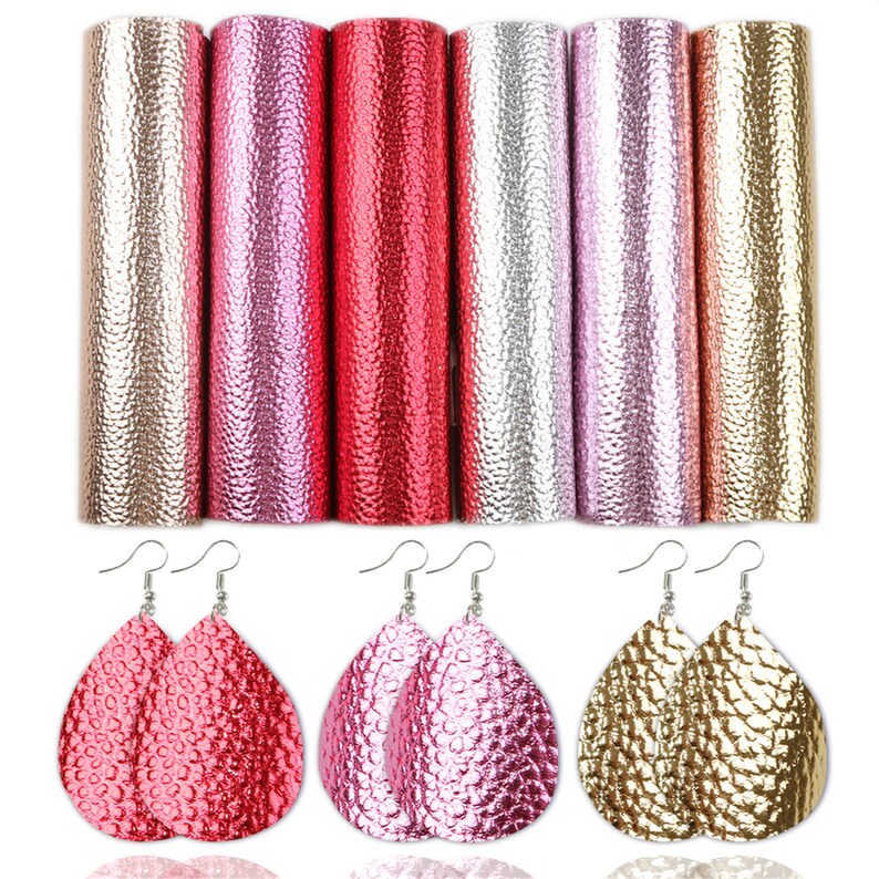 Puede incluir: Seis hojas de piel sint&eacute;tica en colores dorado, rosa y rojo. La piel tiene un aspecto texturizado y en relieve. Tres pares de pendientes en forma de l&aacute;grima hechos de piel sint&eacute;tica se muestran debajo de las hojas.