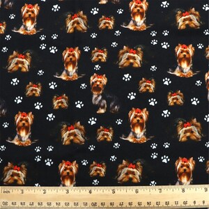 May include: Black fabric with a repeating pattern of Yorkshire Terrier dogs wearing red bows and white paw prints.