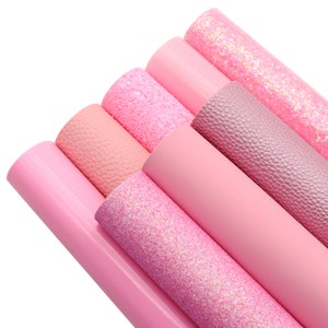 May include: A collection of pink faux leather sheets in various textures. The sheets include smooth, glitter, and textured finishes, ranging in shades from light to deep pink. Ideal for crafting and DIY projects.