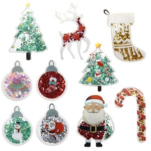 May include: A set of ten Christmas-themed glitter ornaments and stickers. The ornaments include a Christmas tree, a reindeer, a stocking, a Santa Claus, a candy cane, and three ornaments with different designs. The stickers include a Christmas tree and a Santa Claus.