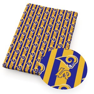 Puede incluir: Tela a rayas azules y doradas con un patr&oacute;n repetido del logotipo de los Los Angeles Rams.