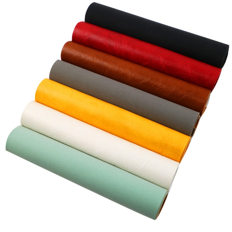 May include: A set of eight faux leather sheets in various colours, including black, red, brown, grey, yellow, white, and green. The sheets are rolled up and stacked on top of each other.