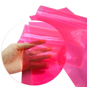 May include: A sheet of translucent pink glitter vinyl. The vinyl is flexible and has a shiny finish.