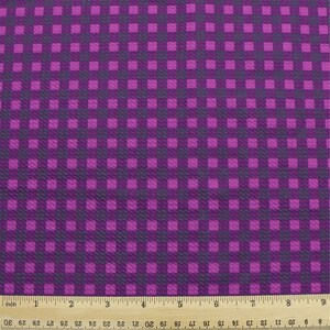 May include: Purple and dark purple checkered fabric with a textured surface.