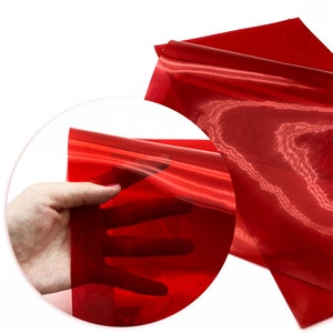 May include: A sheet of translucent red vinyl with a slight sheen. The vinyl is flexible and can be used for a variety of craft projects.