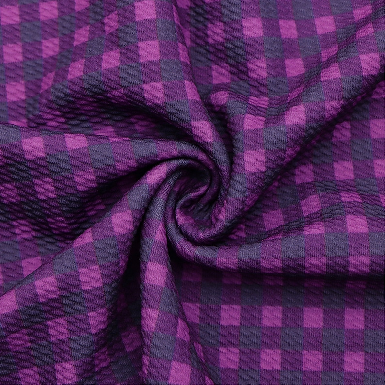 May include: Purple and dark purple checkered fabric with a textured surface.