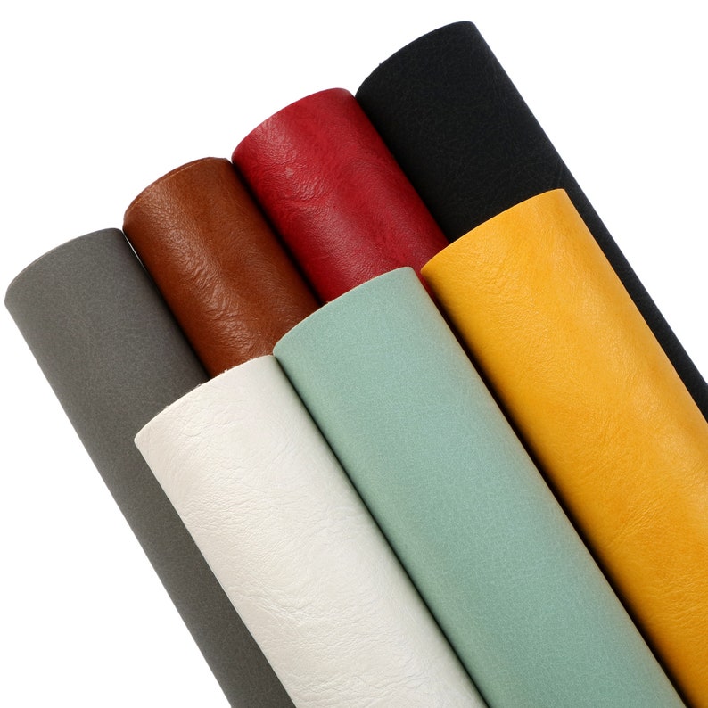 May include: A set of seven faux leather rolls in various colours, including grey, white, light blue, brown, red, yellow, and black.