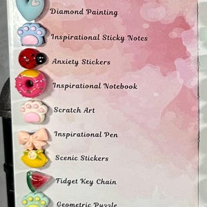 May include: A white board with the text "Balancing" and "Mind: Inspire and Refresh." The board lists various items, including Diamond Painting, Inspirational Sticky Notes, Anxiety Stickers, and a Fidget Key Chain. Decorative flower and heart-shaped embellishments are at the top.