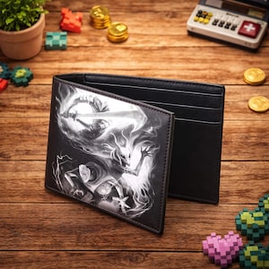 May include: Black bi-fold wallet with a fantasy art design. The wallet is open, revealing a black interior with card slots. The exterior features a detailed black and white illustration of a warrior and a creature. The wallet is made of a leather-like material.
