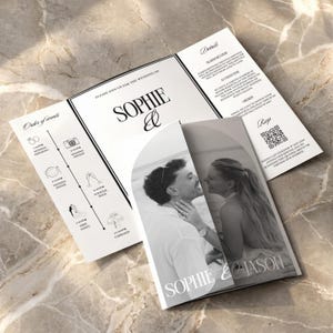 May include: A wedding invitation suite featuring a black and white photo of a couple kissing. The invitation includes the names "Sophie & Jason" and details about the wedding ceremony, dinner, and reception.