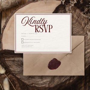 Puede incluir: Una tarjeta de confirmaci&oacute;n de asistencia de color crema con texto burdeos y un borde doble. La tarjeta dice "Kindly RSVP" e incluye l&iacute;neas para nombres, aceptaci&oacute;n y requisitos diet&eacute;ticos. Tambi&eacute;n hay un sobre marr&oacute;n con un sello de cera burdeos.