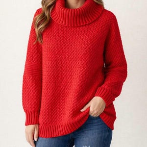 May include: A bright red knitted jumper featuring a textured design and a roll neck. The long-sleeved jumper has ribbed cuffs and a ribbed hem. The model is wearing blue jeans. The image is from Bukhari Nest.