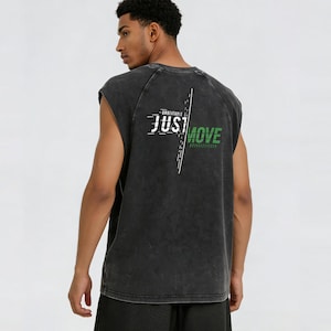 May include: A sleeveless, charcoal gray workout shirt with the text "JUST MOVE" in white and green. The shirt has a distressed look and a crew neck. The words "UNBEATABLE" and "REVOLUTION" are also printed on the shirt.