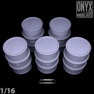 May include: Six light purple model barrels are stacked, each with the text "Kraftstoff 200L Wehrmacht" on the lids. A silver paperclip is next to the barrels. The text "1/16" is at the bottom left corner.
