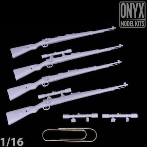 May include: Four light grey model rifles with scopes, two additional scopes, and a paperclip. The rifles are detailed with various components. The text "ONYX MODEL KITS" is in the upper right corner. The scale "1/16" is in the lower left corner.