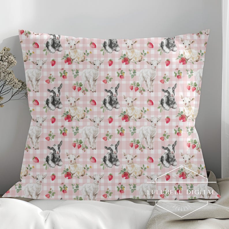 May include: A decorative pillow with a repeating pattern of watercolor goats, strawberries, and floral accents on a pink and white gingham background. The pillow is rectangular and appears to be made of fabric.