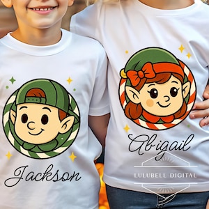 Może przedstawiać: Białe koszulki z kreskówkowymi twarzami elfów w zielonych i czerwonych okręgach. Jedna koszulka mówi "Jackson", a druga "Abigail" kursywą. Koszulki mają żółte gwiazdki i zielone diamenty. Na dole wydrukowano "LULUBELL DIGITAL".