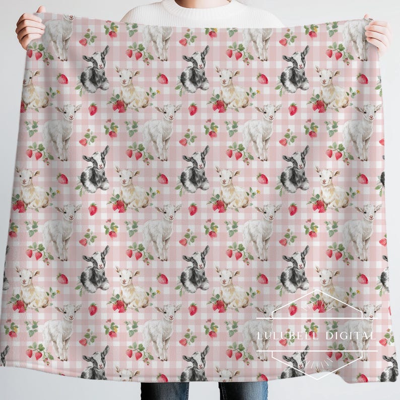 May include: A pink and white gingham patterned blanket featuring watercolor illustrations of goats and strawberries. The blanket has a repeating pattern of white and black goats, strawberries, and floral accents.