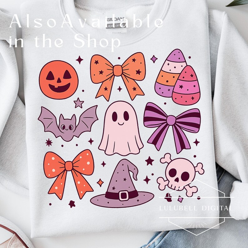 May include: White sweatshirt featuring a collection of Halloween-themed illustrations. The design includes a jack-o'-lantern, bows, a bat, a ghost, candy corn, a witch's hat, a skull, and stars. The text "Also Available in the Shop" is visible.
