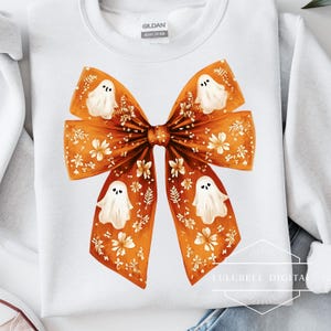 An oversized orange ribbon bow features soft painted brushstrokes, delicate white flowers, and four cute little white ghosts with smiling faces. The bow has a whimsical coquette style, perfect for Halloween crafts, soft spooky designs, or autumn-themed decor.