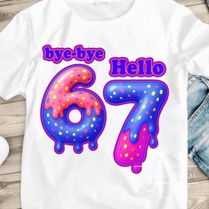 Peut inclure: T-shirt blanc avec un motif graphique coloré. Le motif présente les mots "bye-bye" et "Hello" au-dessus des chiffres "67". Les chiffres sont décorés de points roses, bleus et jaunes.