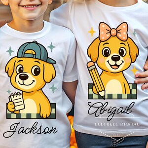 Pode incluir: T-shirts brancas com gráficos de cães de desenho animado. Um cão usa um boné azul e segura um bloco de notas, o outro tem um laço e um lápis. Os nomes "Jackson" e "Abigail" estão abaixo dos gráficos. O texto "LULUBELL DIGITAL" também é visível.