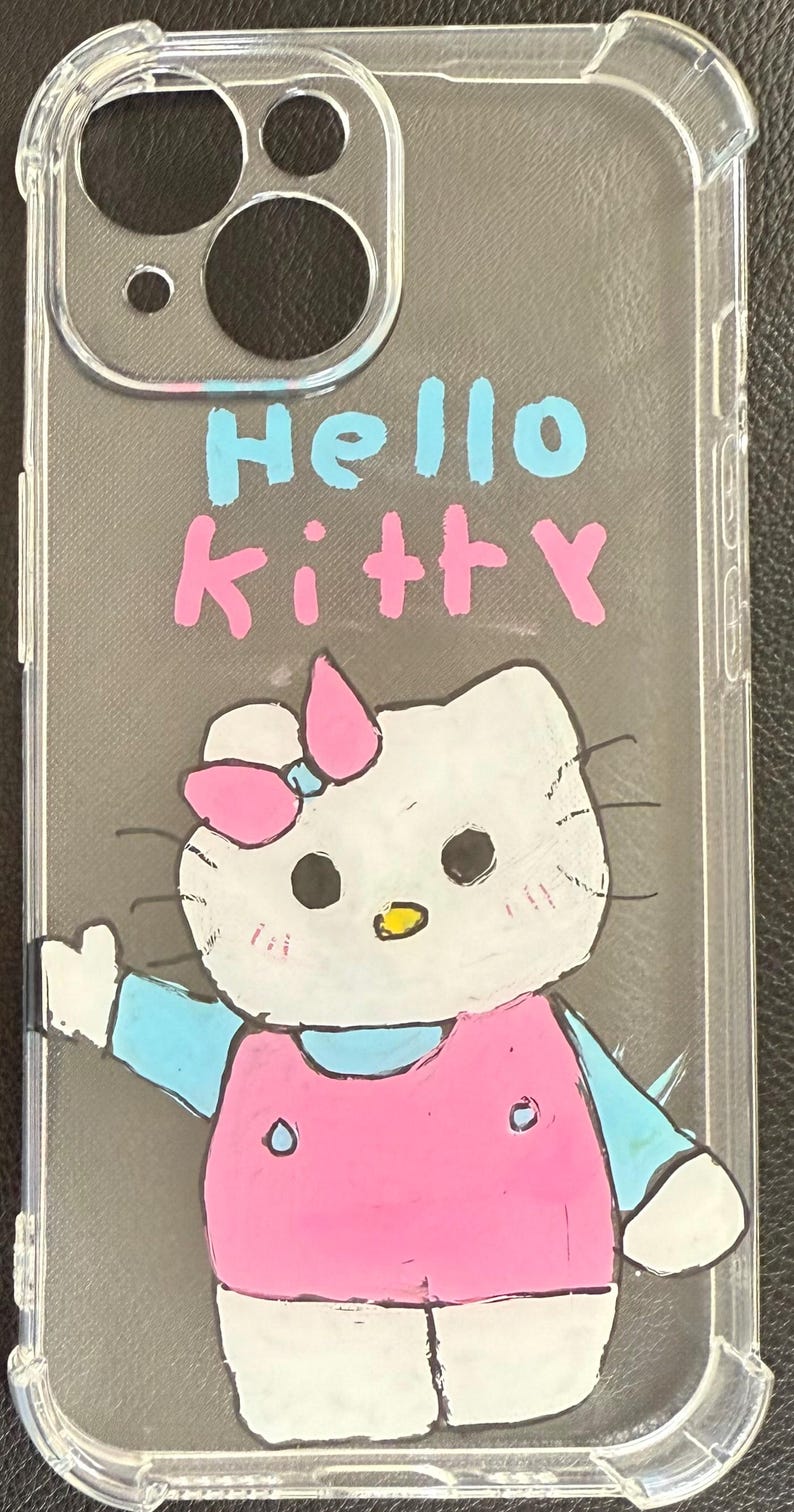 Puede incluir: Funda transparente para tel&eacute;fono con un dise&ntilde;o de Hello Kitty dibujado a mano. El dise&ntilde;o incluye un gato blanco con un lazo rosa, un vestido rosa y detalles azules. Las palabras "Hello Kitty" est&aacute;n escritas en azul y rosa.
