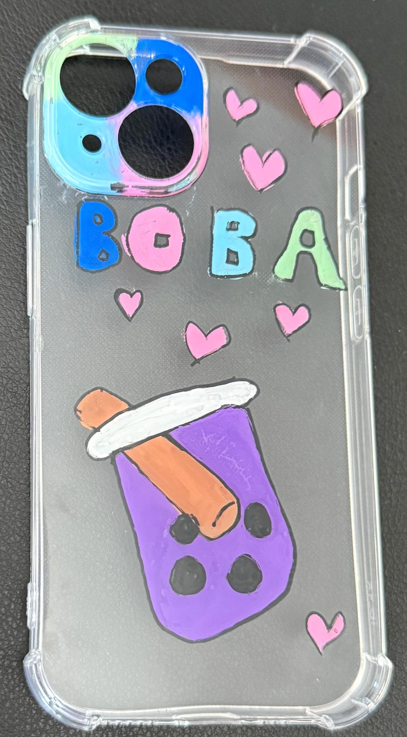 Puede incluir: Funda transparente para tel&eacute;fono con un dise&ntilde;o colorido. La funda presenta la palabra "BOBA" en letras azules, rosas y verdes, junto con corazones rosas y una ilustraci&oacute;n de t&eacute; boba morado. La funda est&aacute; dise&ntilde;ada para un tel&eacute;fono.