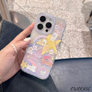 May include: Transparent phone case with a playful design of cartoon cats, stars, and a rainbow. The case has a lilac border and the text "love to live, to dream". The case is designed for a smartphone.