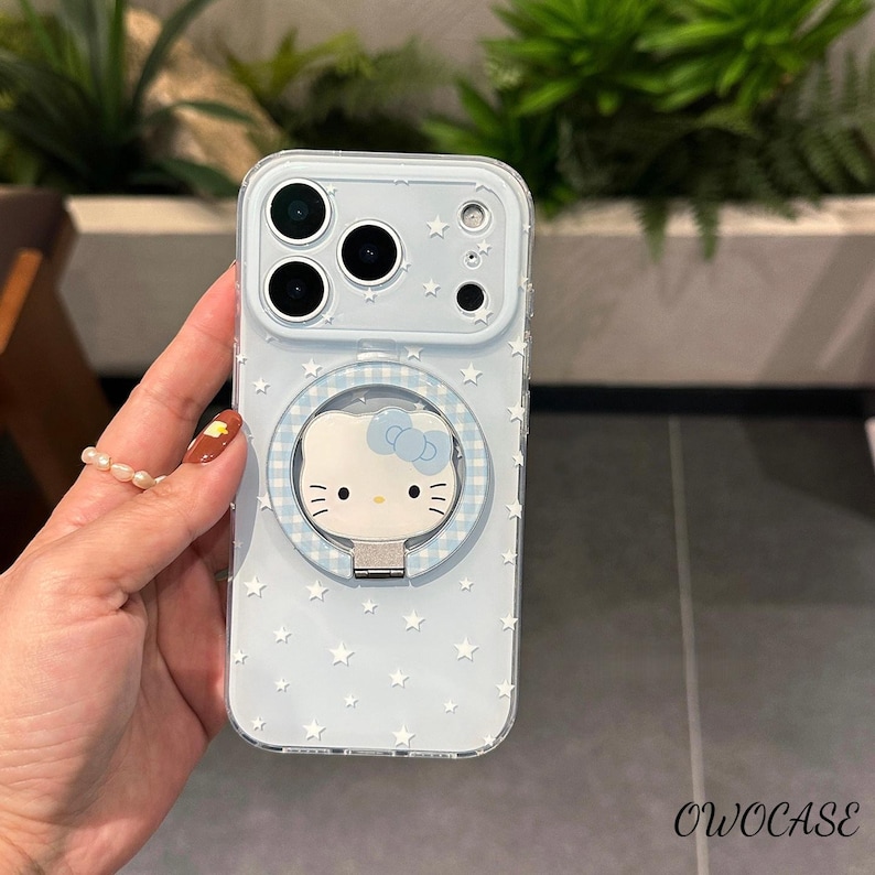 May include: A light blue phone case with a white star pattern and a Hello Kitty design. The case has a ring holder and the text "OWOCASE" in the bottom right corner.