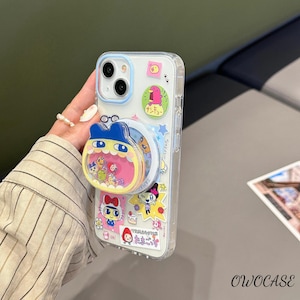 May include: Clear phone case with a blue camera ring and a pop-up grip featuring cartoon characters. The case is decorated with colorful stickers of various characters. The brand name "OWOCASE" is printed in the bottom right corner.