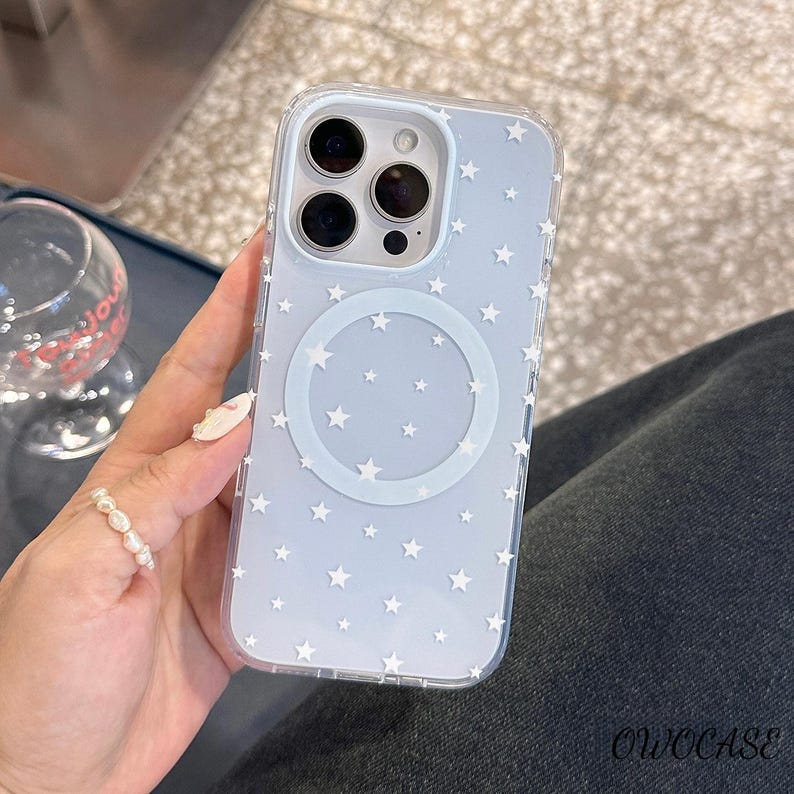 May include: Clear phone case with a light blue background and white star pattern. The case has a circular design in the center and a camera cutout. The brand name "OWOCASE" is printed in the bottom right corner.