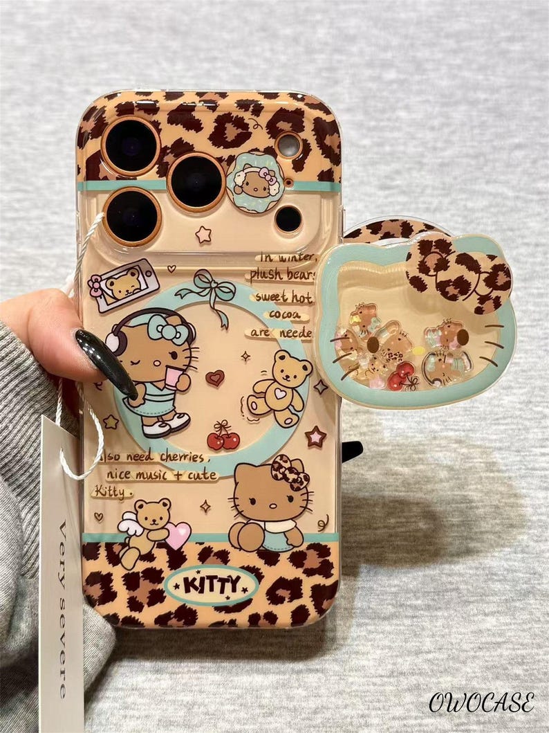 May include: A clear phone case with a leopard print design and Hello Kitty illustrations. The case features a detachable Hello Kitty head with floating glitter and small figures. Text includes "In winter, plush bears, sweet hot cocoa are needed" and "Kitty."