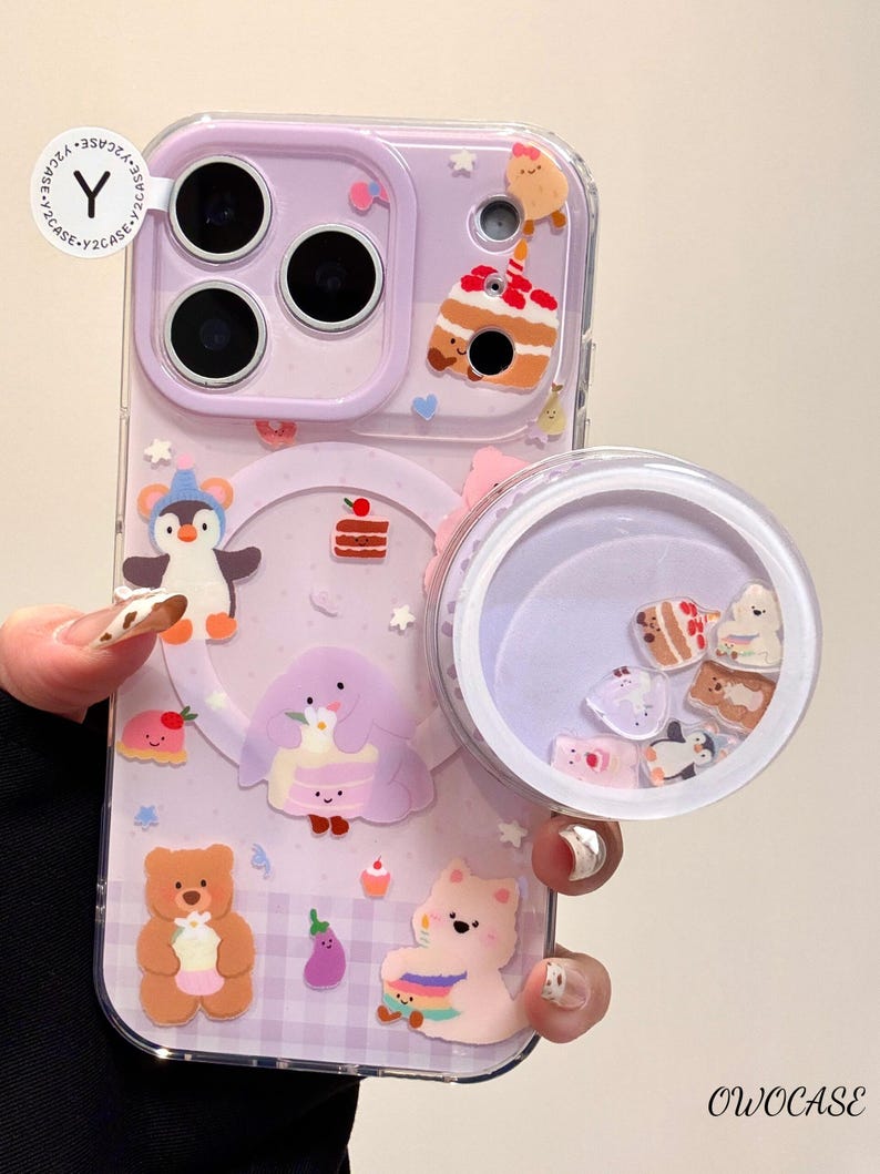 May include: A lavender phone case with a clear, round, liquid-filled compartment. The case features various cartoon food and animal designs, including a penguin, bear, and cake. The text "Y2CASE" and "OWOCASE" are visible.