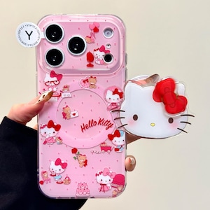 Pu&ograve; includere: Custodia per telefono rosa con personaggi di Hello Kitty e la scritta "Hello Kitty". La custodia ha un bordo trasparente e un ciondolo 3D di Hello Kitty. Il design include fiocchi, orsi e torte. La custodia &egrave; progettata per un telefono.