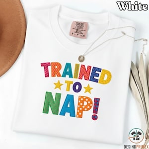 Op de afbeelding: Een witte keramische mok met een zwart handvat en de tekst "But First, Coffee" in een zwarte, handgeschreven lettertype. De mok staat op een wit oppervlak.