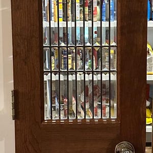 May include: A wooden door with a decorative glass panel. The door is made of dark wood and features a rectangular glass panel divided into smaller sections. A silver doorknob is visible.