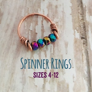 May include: A copper spinner ring with iridescent beads. The ring is available in sizes 4-12. Spinner Rings Sizes 4-12