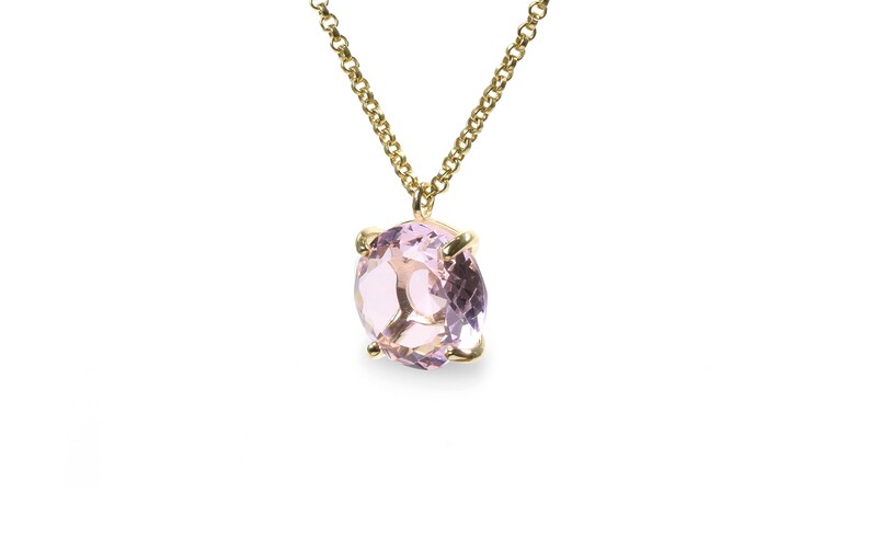 May include: A delicate gold chain necklace with a pale pink oval gemstone pendant.