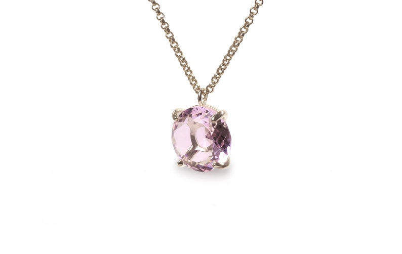 May include: A delicate gold chain necklace with a light pink gemstone pendant.
