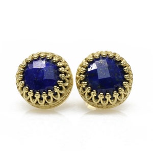 May include: A pair of gold earrings with a blue lapis lazuli stone set in each. The stones are faceted and have a gold filigree design around the edges.
