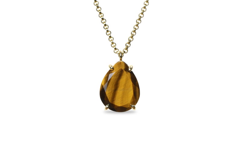May include: A gold chain necklace with a teardrop-shaped tiger's eye gemstone pendant.