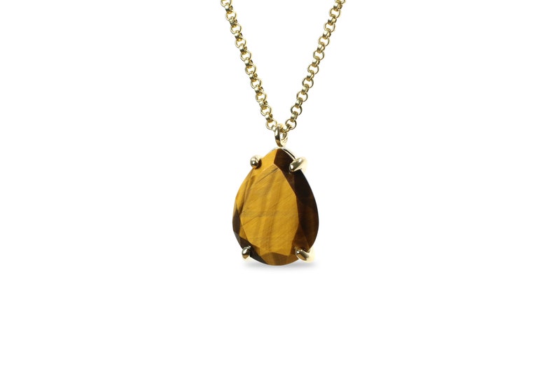 May include: A gold chain necklace with a teardrop-shaped tiger's eye pendant.